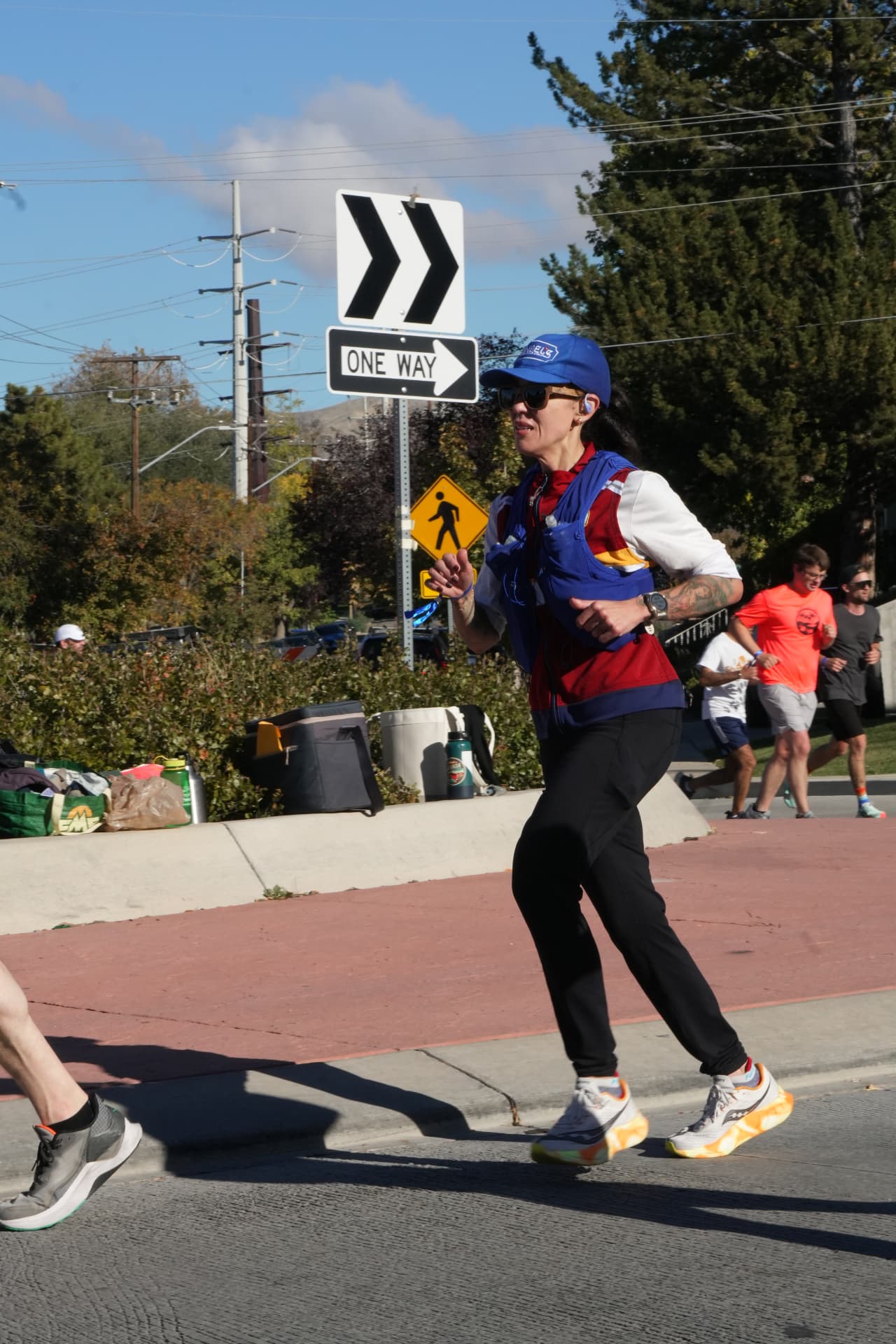 Dani running outdoors in a blue cap and hydration vest.